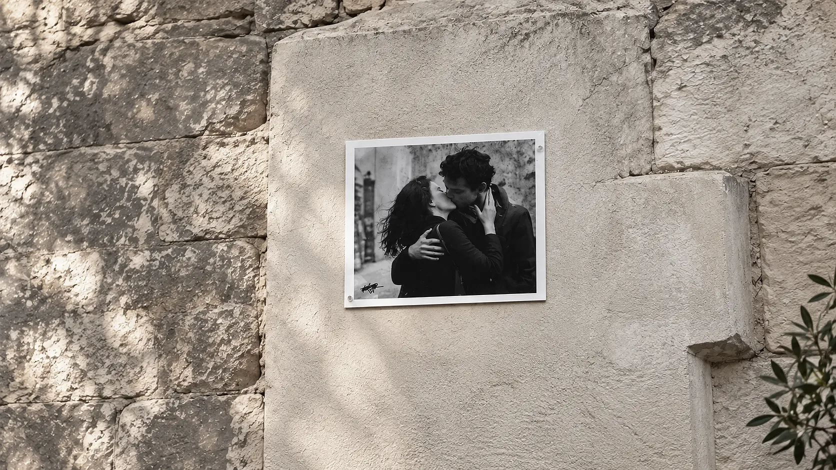 Black-and-white photograph of a couple kissing on a stone wall - private matchmaking in New York