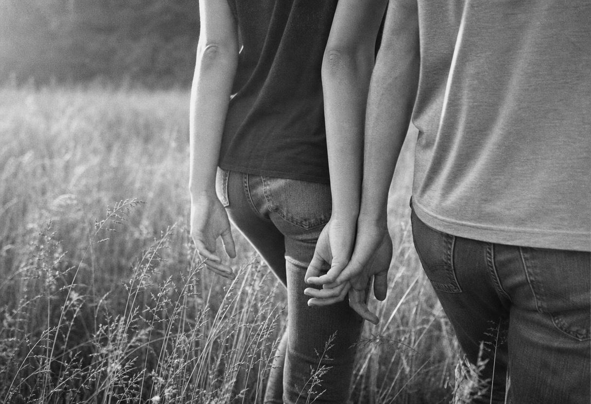 Two people walking hand in hand through a sunlit meadow — the outcome elite matchmaking services are priced against